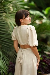 Photo of Beautiful woman posing in tropical forest, back view