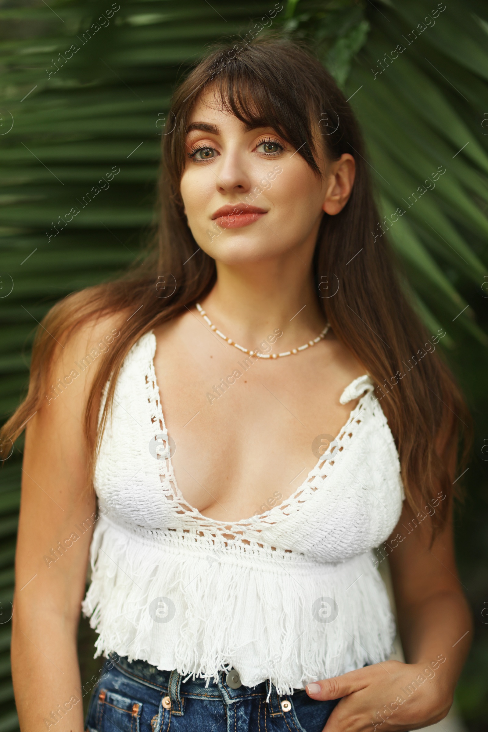 Photo of Portrait of beautiful woman near palm leaves outdoors