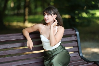 Beautiful woman sitting on bench in park