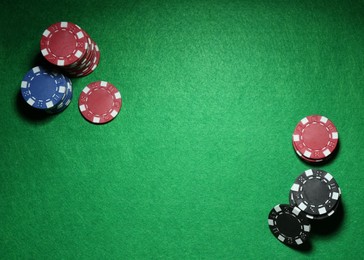 Poker chips on green table, flat lay. Space for text