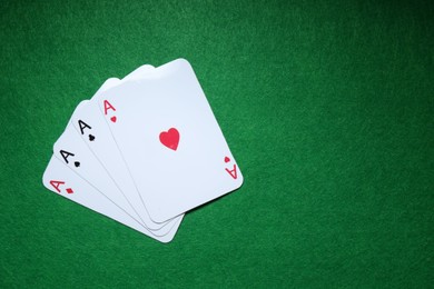 Poker game. Playing cards on green table, flat lay. Space for text