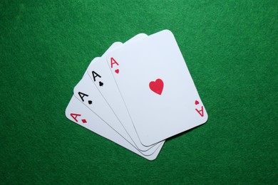 Poker game. Playing cards on green table, flat lay