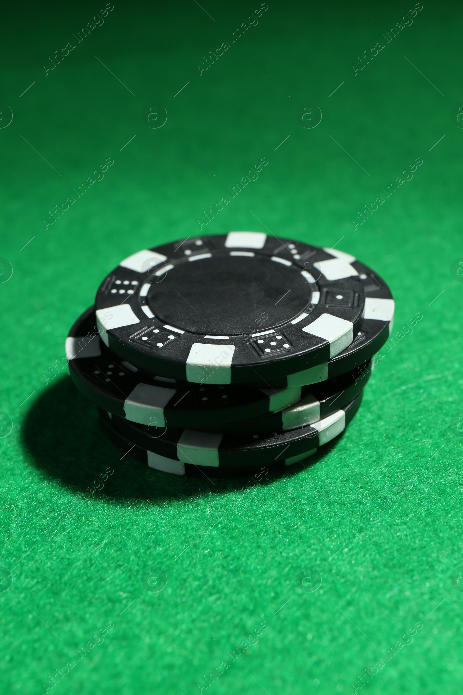 Photo of Stack of poker chips on green table, closeup