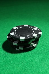 Stack of poker chips on green table, closeup