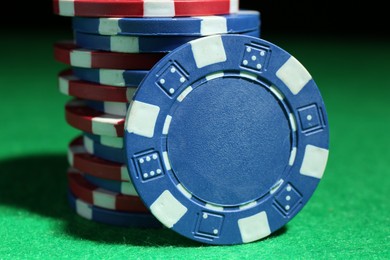 Photo of Poker chips on green table, closeup view