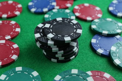 Photo of Group of poker chips on green table, closeup