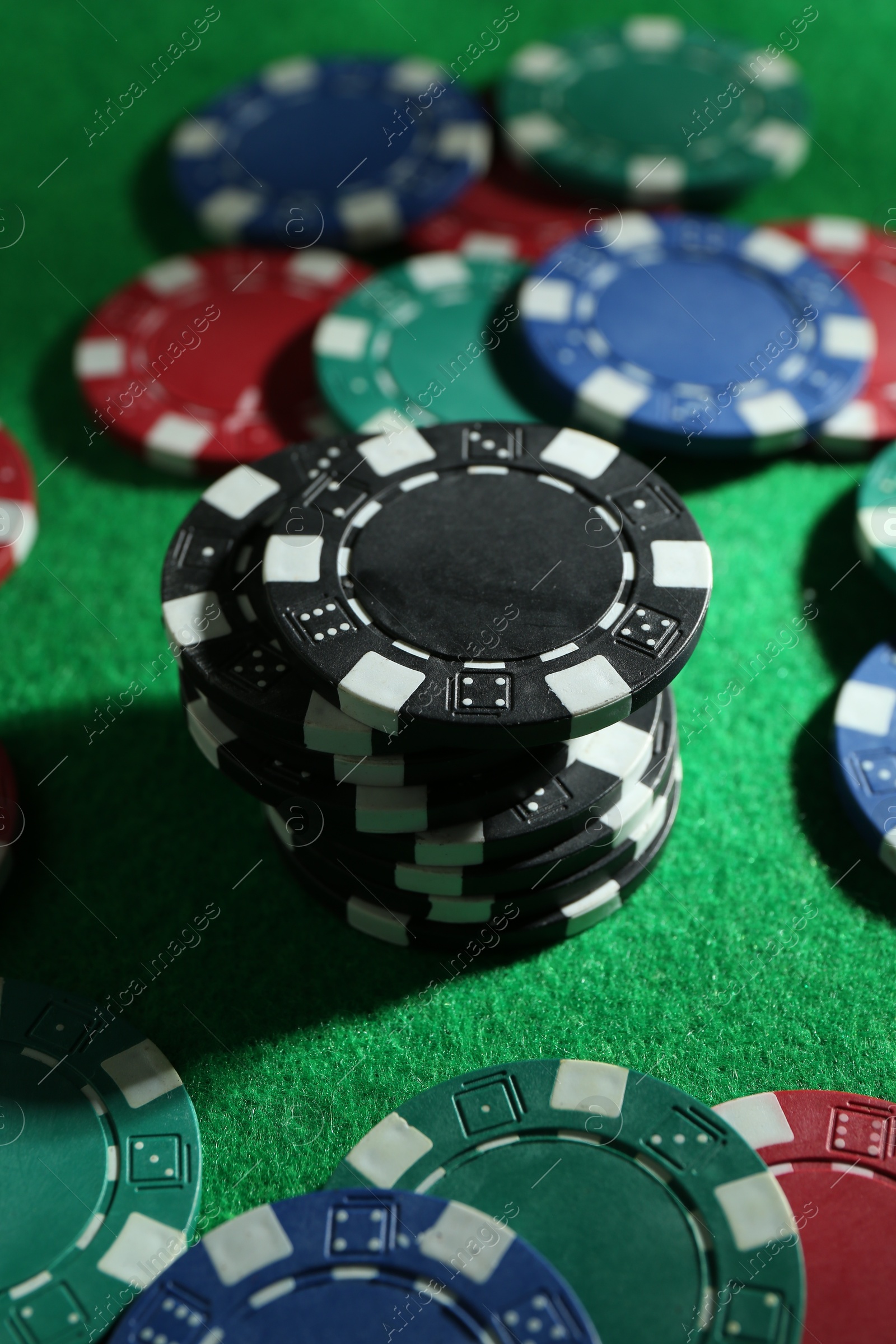 Photo of Group of poker chips on green table, closeup