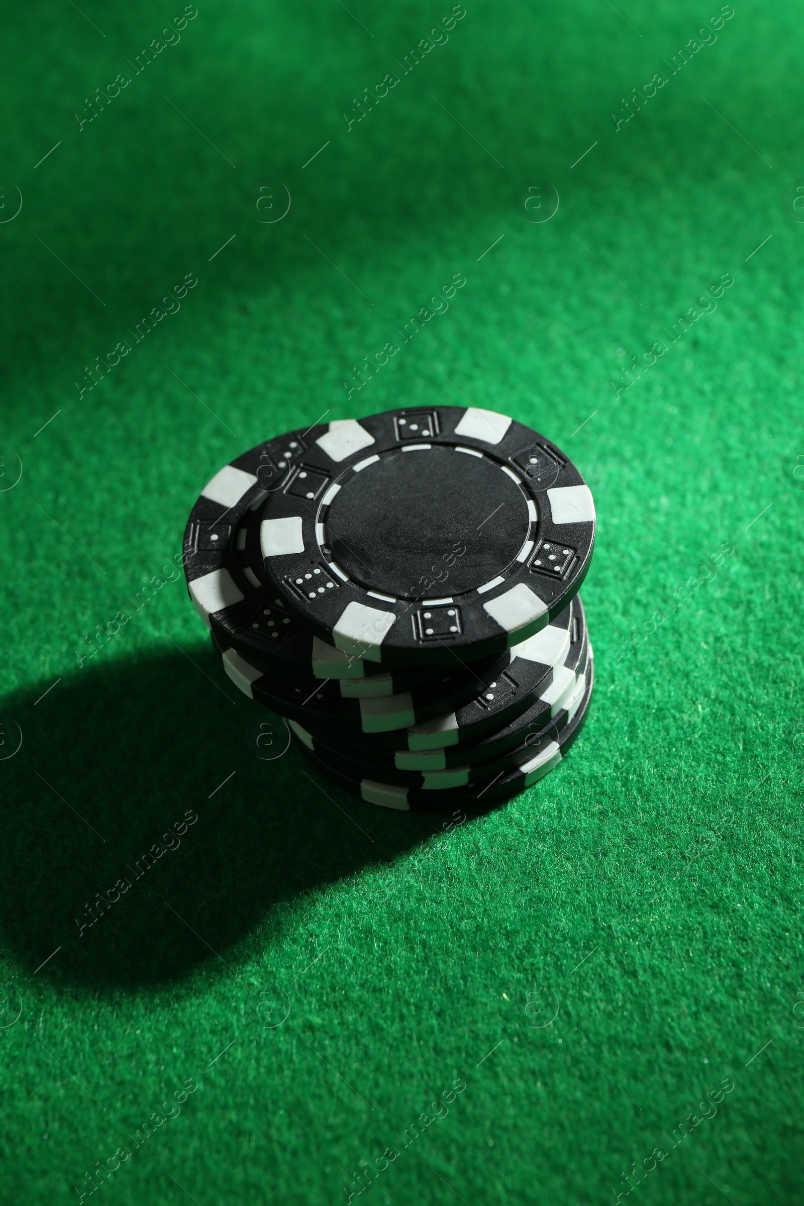 Photo of Stack of poker chips on green table, closeup