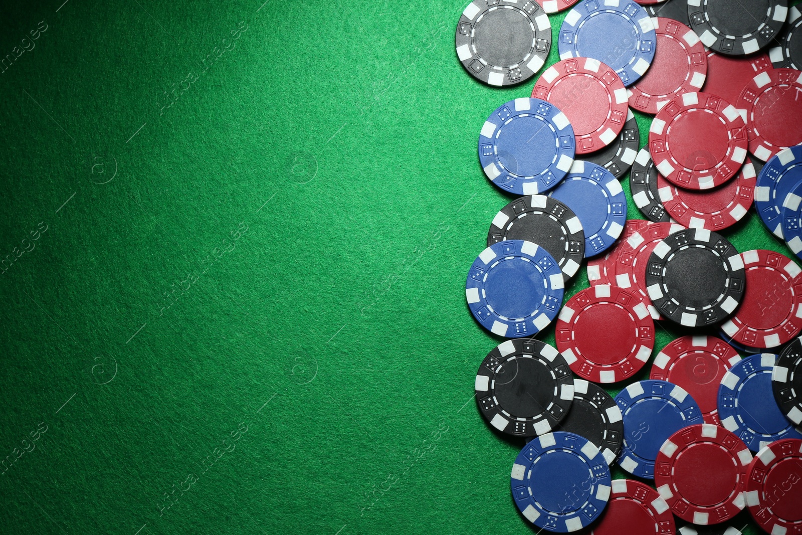 Photo of Poker chips on green table, flat lay. Space for text