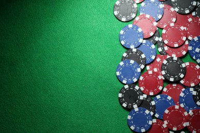 Photo of Poker chips on green table, flat lay. Space for text