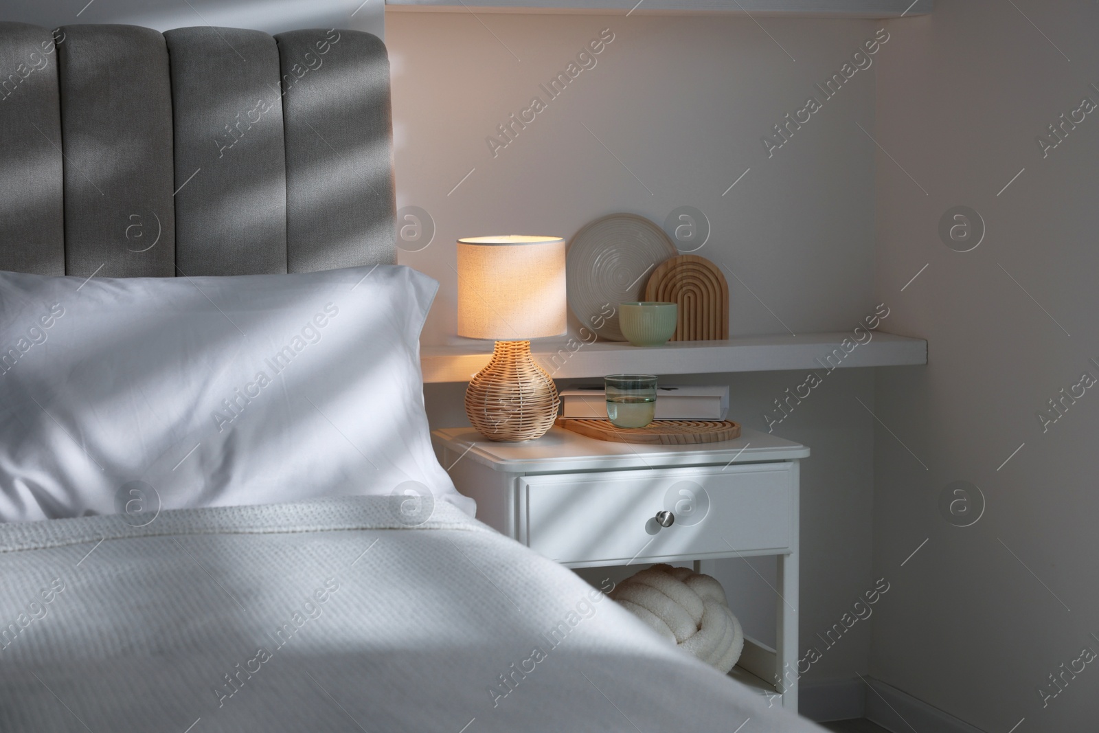 Photo of Stylish living room interior with bed, bedside table and lamp