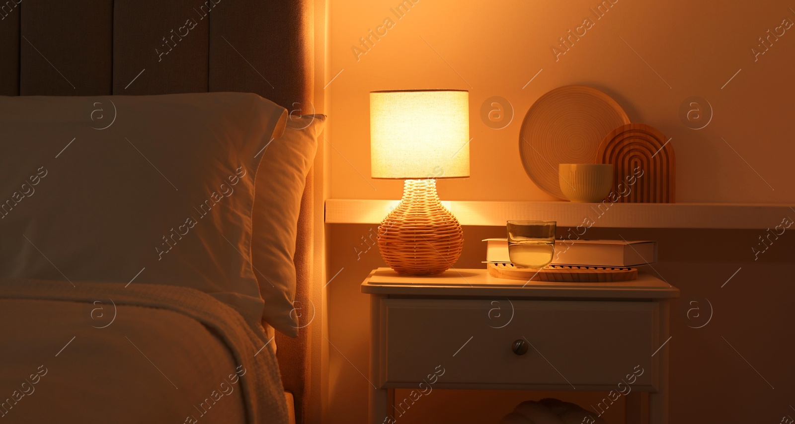 Photo of Stylish living room interior with bed, bedside table and lamp