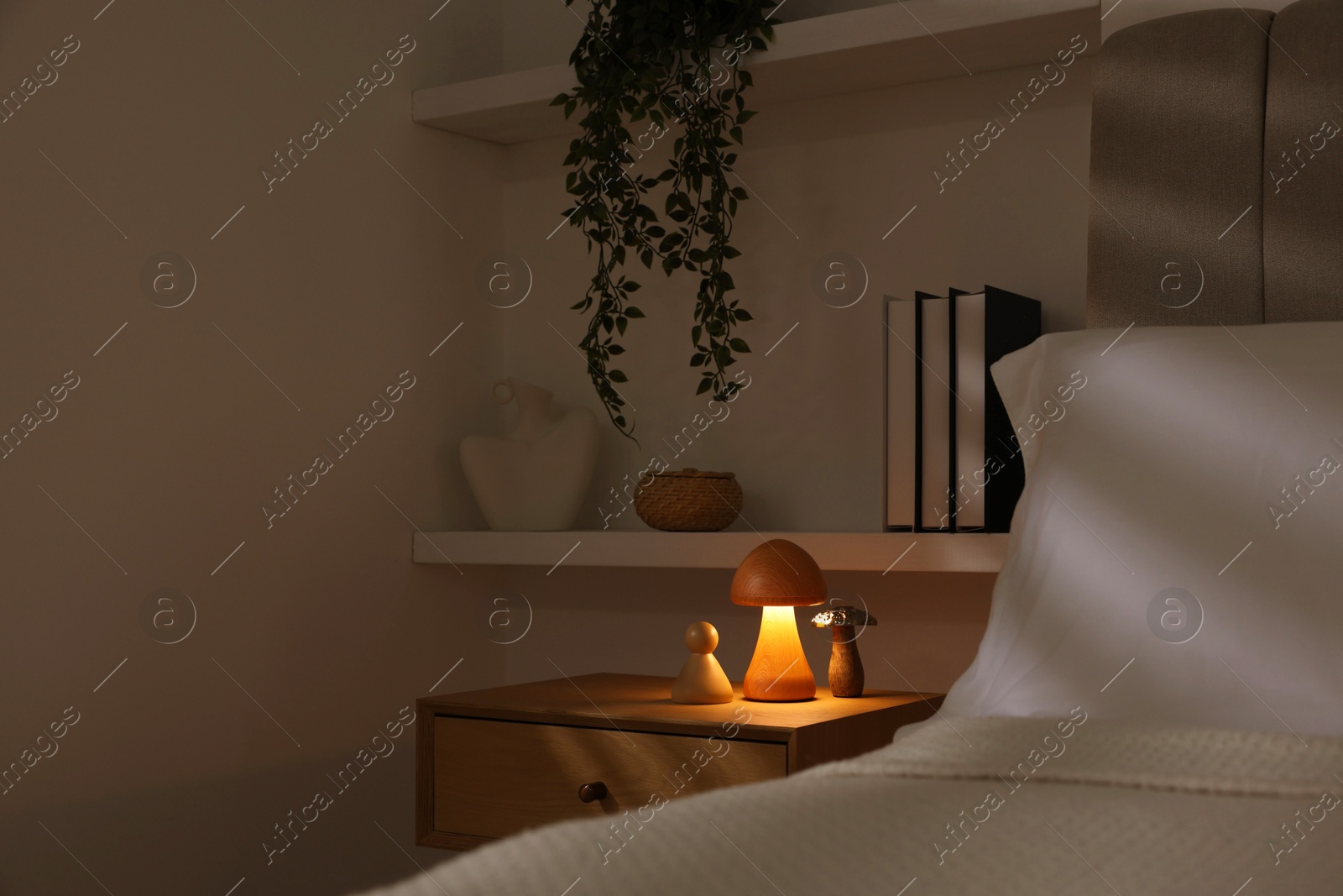 Photo of Stylish living room interior with bed, bedside table and night light