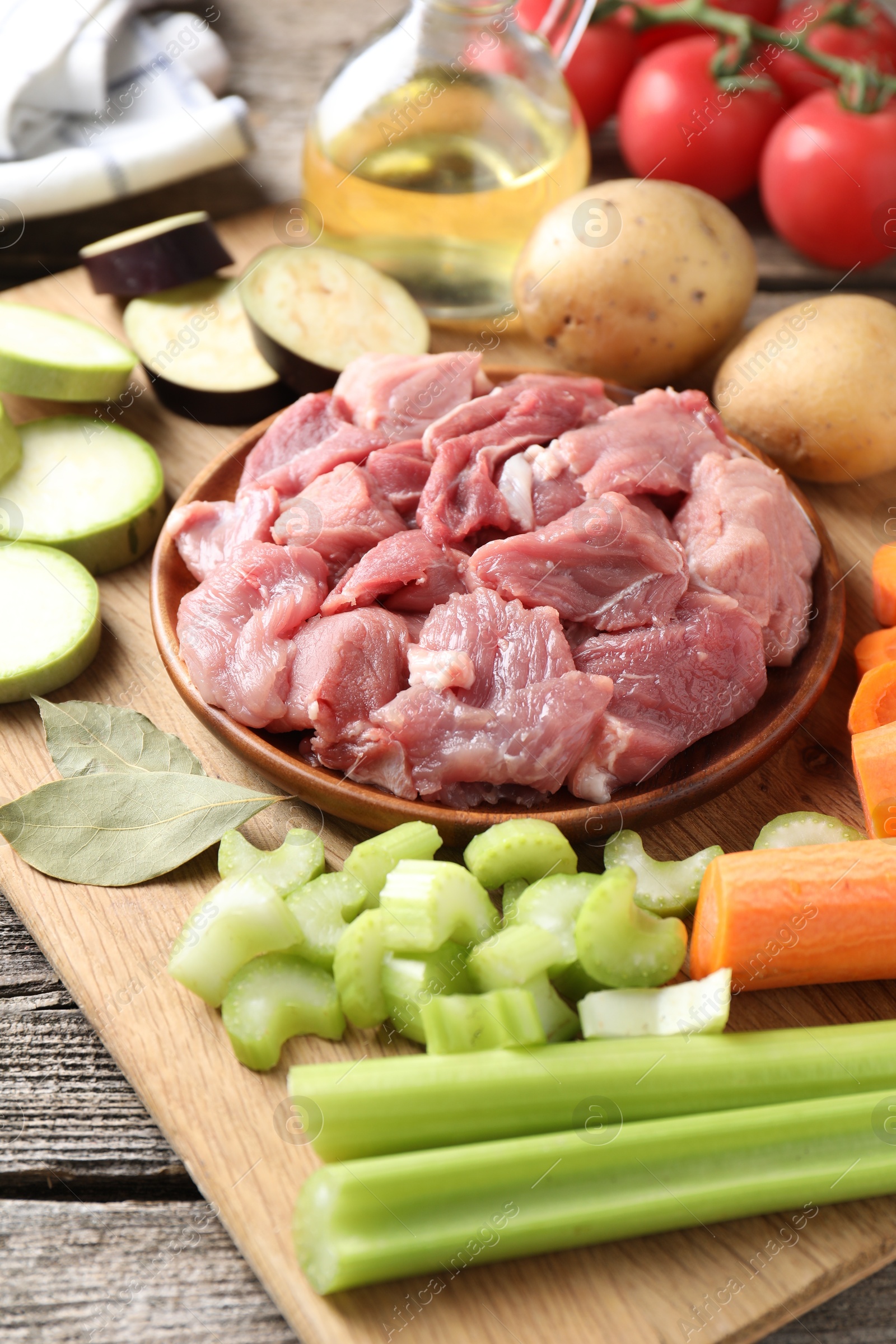 Photo of Cooking stew. Uncooked meat and vegetables on wooden table