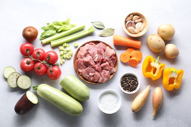 Photo of Cooking stew. Uncooked meat and vegetables on light grey table, flat lay