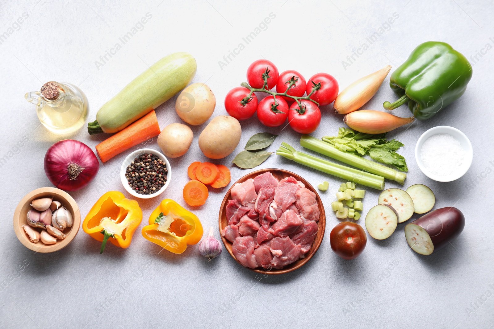 Photo of Cooking stew. Uncooked meat and vegetables on light grey table, flat lay