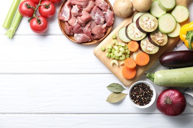 Photo of Cooking stew. Uncooked meat and vegetables on white wooden table, flat lay. Space for text