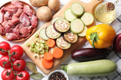 Photo of Cooking stew. Uncooked meat and vegetables on white wooden table, flat lay