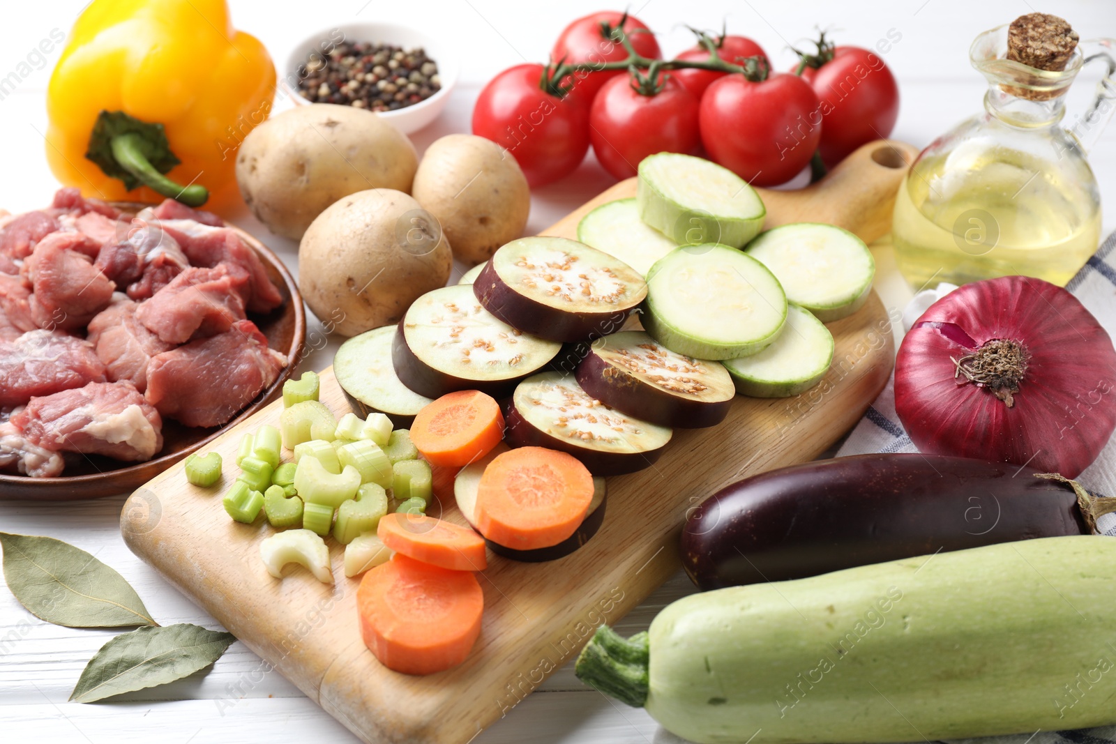 Photo of Cooking stew. Uncooked meat and vegetables on white wooden table