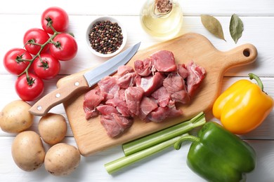 Photo of Cooking stew. Uncooked meat and vegetables on white wooden table, flat lay