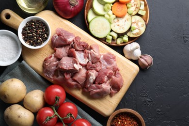 Photo of Cooking stew. Uncooked meat and vegetables on black table, flat lay