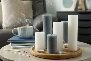 Beautiful burning candles and matches on light table indoors