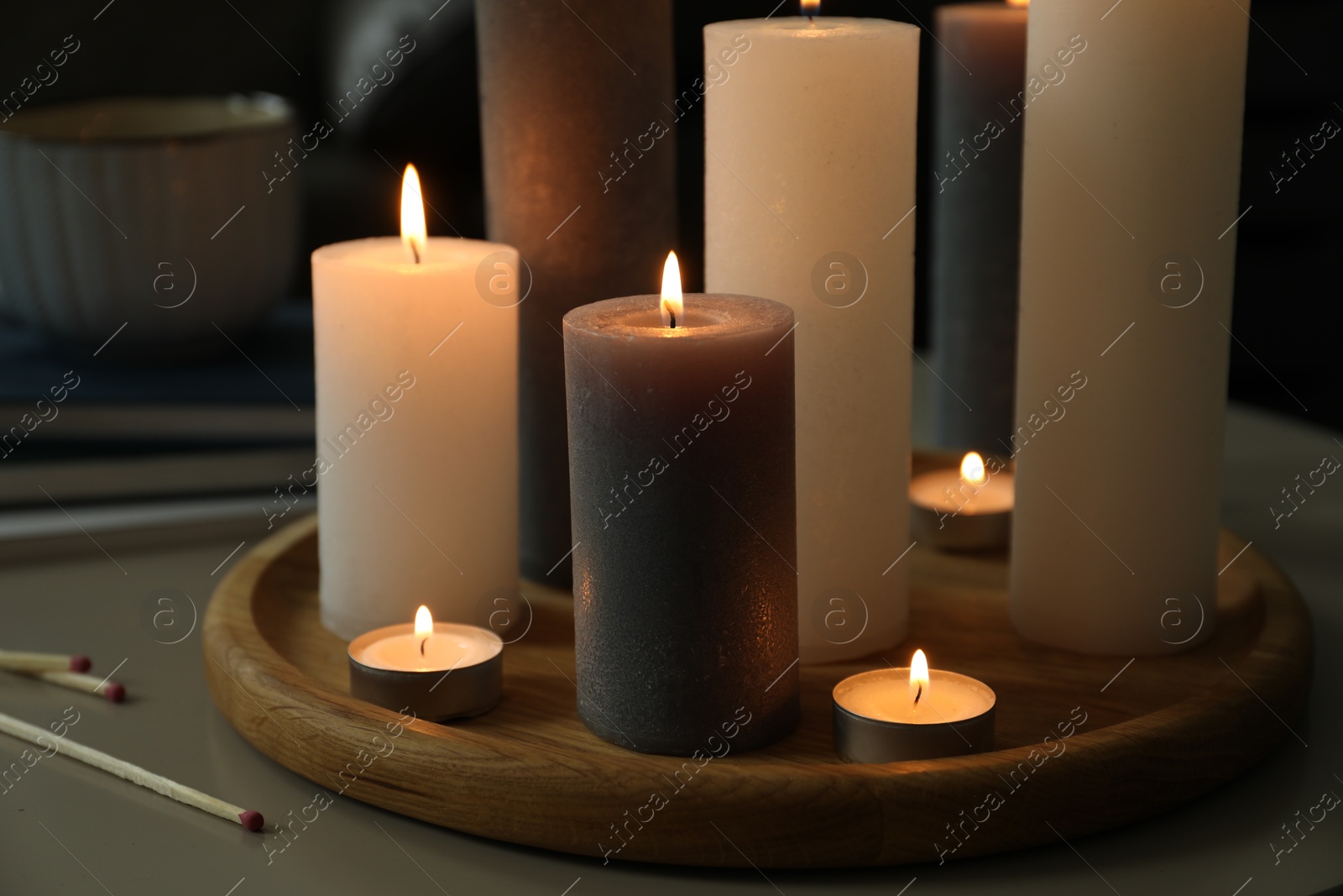 Photo of Beautiful burning candles and matches on table indoors, closeup