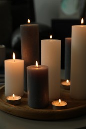 Photo of Beautiful burning candles on table indoors, closeup