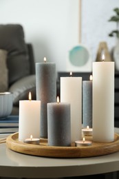 Photo of Beautiful burning candles on light table in room