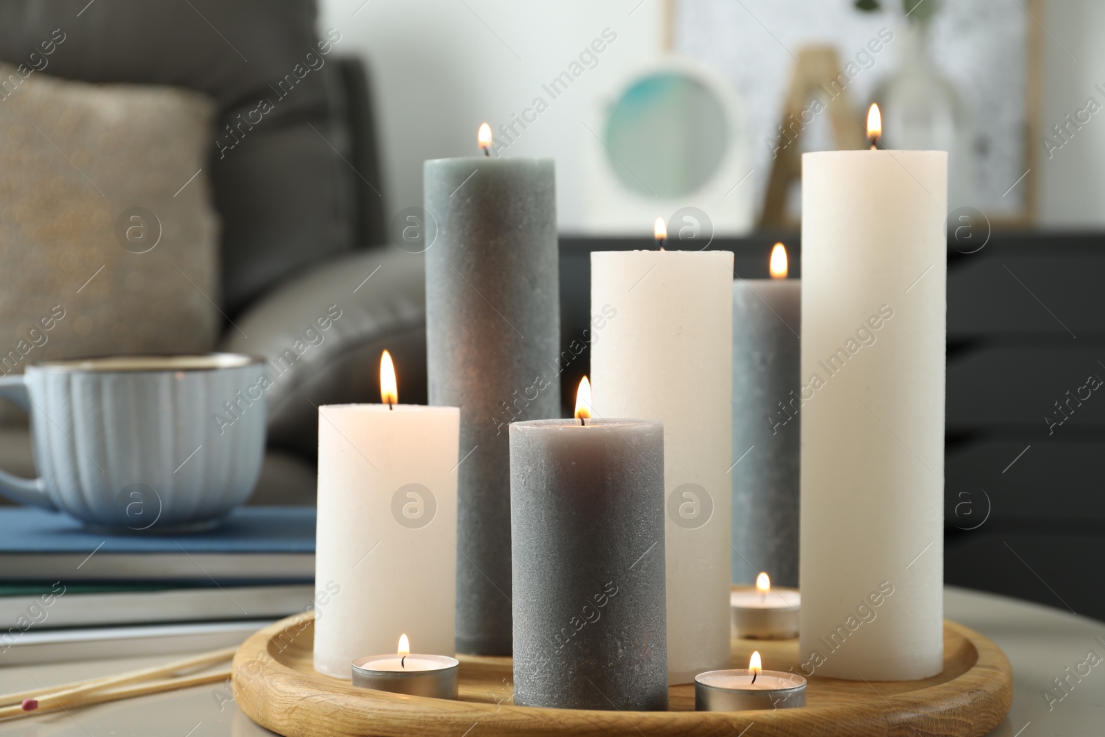 Photo of Beautiful burning candles and matches on light table indoors