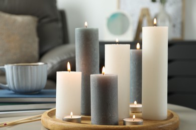 Beautiful burning candles and matches on light table indoors