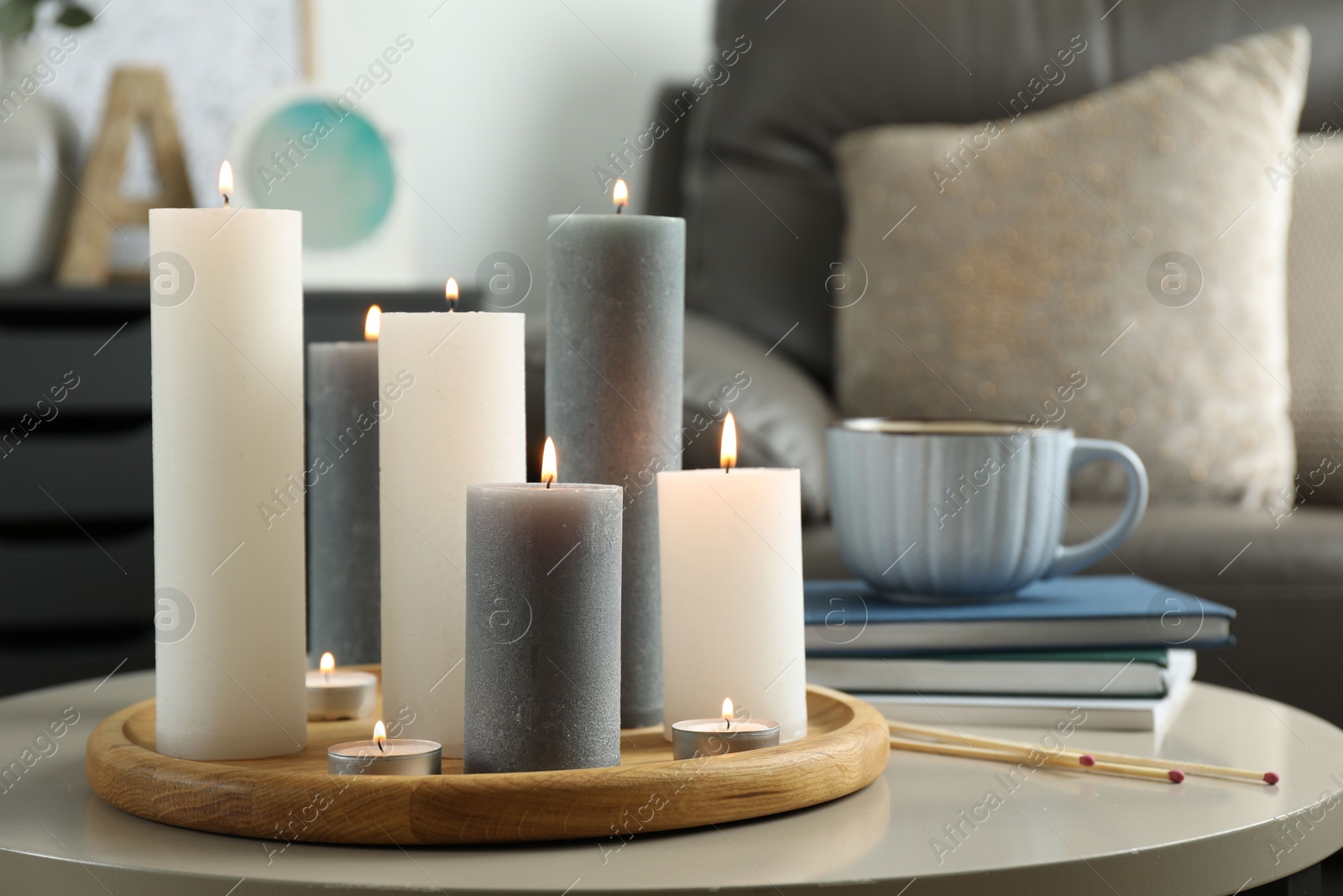 Photo of Beautiful burning candles and matches on light table indoors