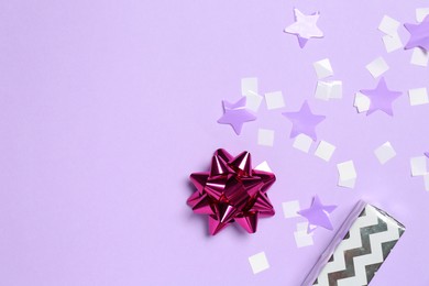 Photo of Shiny confetti and festive decor on violet background, flat lay. Space for text