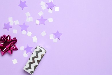 Shiny confetti and festive decor on violet background, flat lay. Space for text