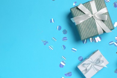 Photo of Gift boxes and shiny confetti on light blue background, flat lay. Space for text