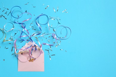 Photo of Shiny confetti and party streamers flying out of envelope on light blue background, flat lay. Space for text