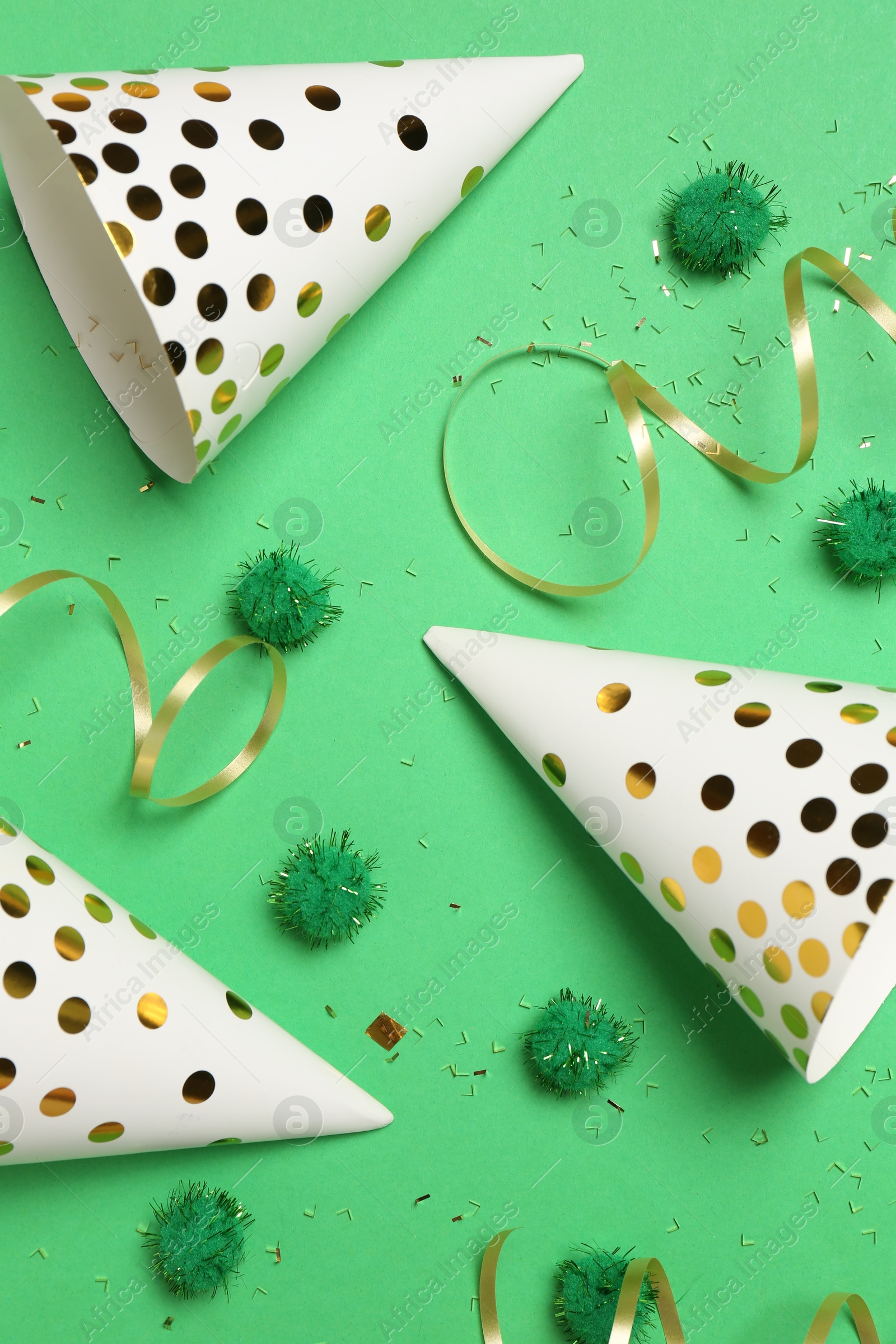 Photo of Festive composition with shiny confetti and party decor on green background, flat lay