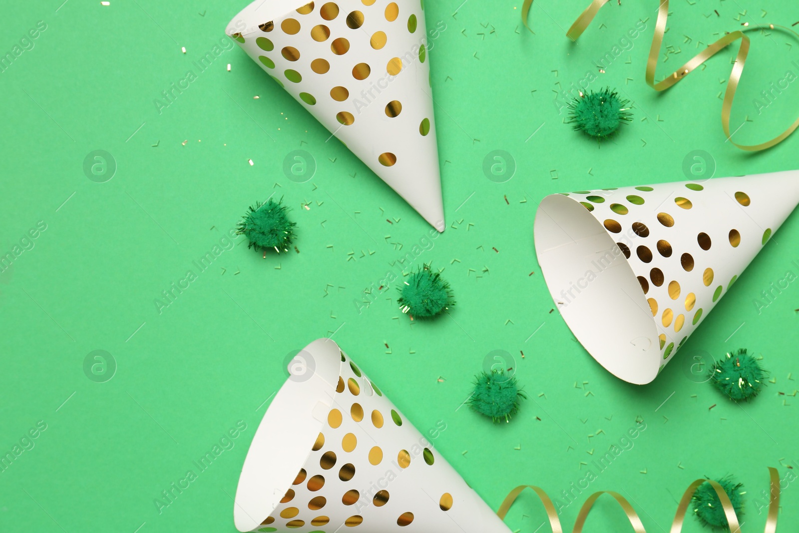 Photo of Festive composition with shiny confetti and party decor on green background, flat lay