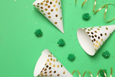 Photo of Festive composition with shiny confetti and party decor on green background, flat lay