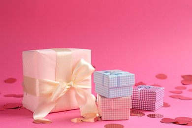 Beautiful confetti and gift boxes on pink background, closeup