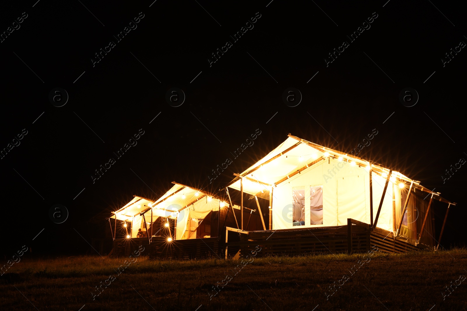 Photo of Tents in mountains at night. Glamping site