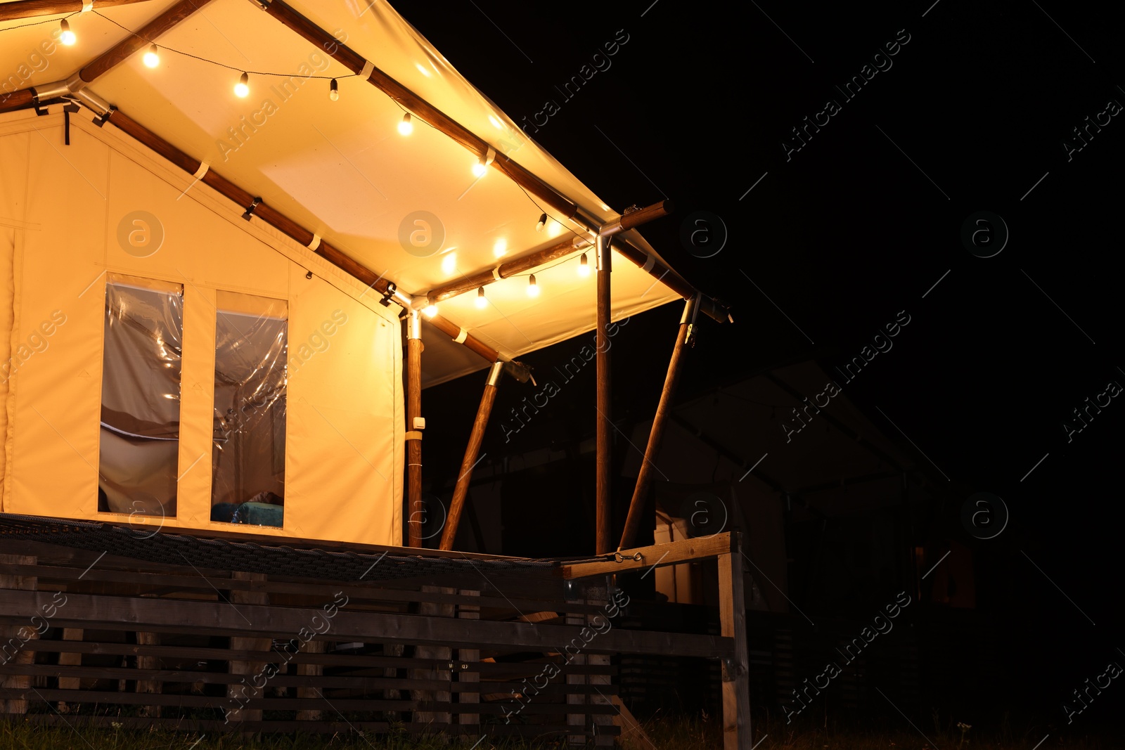 Photo of Tent in mountains at night, space for text. Glamping site