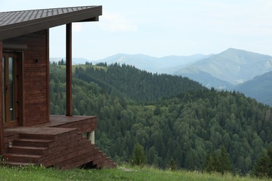 Photo of Picturesque view of wooden building, forest and mountains