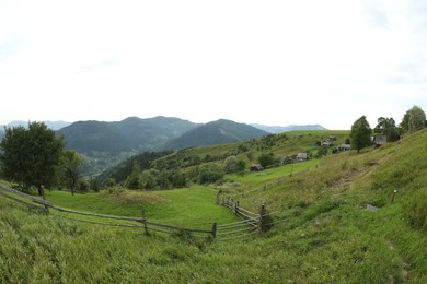 Beautiful view of wooden fence in mountains under sky