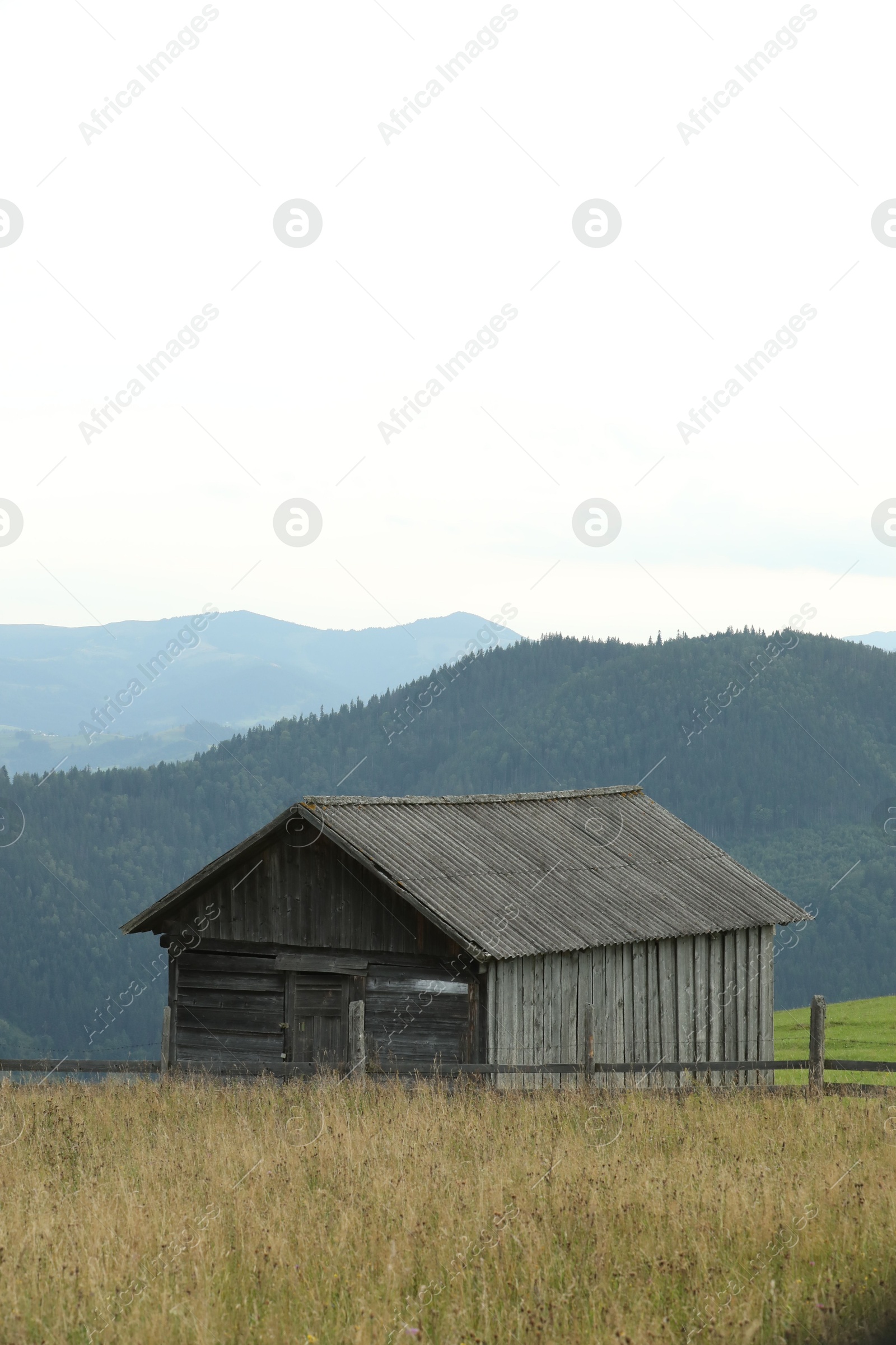 Photo of Beautiful view of forest and building in mountains under sky