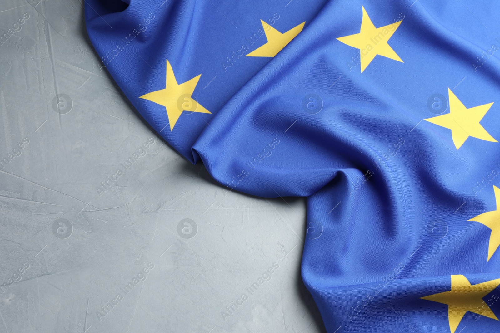 Photo of Flag of European Union on light grey table, top view