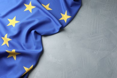 Photo of Flag of European Union on light grey table, top view. Space for text