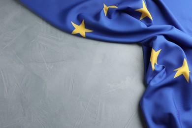 Photo of Flag of European Union on light grey table, above view. Space for text