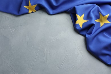 Photo of Flag of European Union on light grey table, top view. Space for text