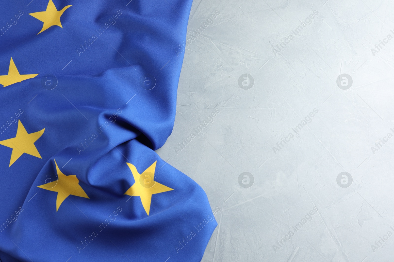 Photo of Flag of European Union on light grey table, space for text